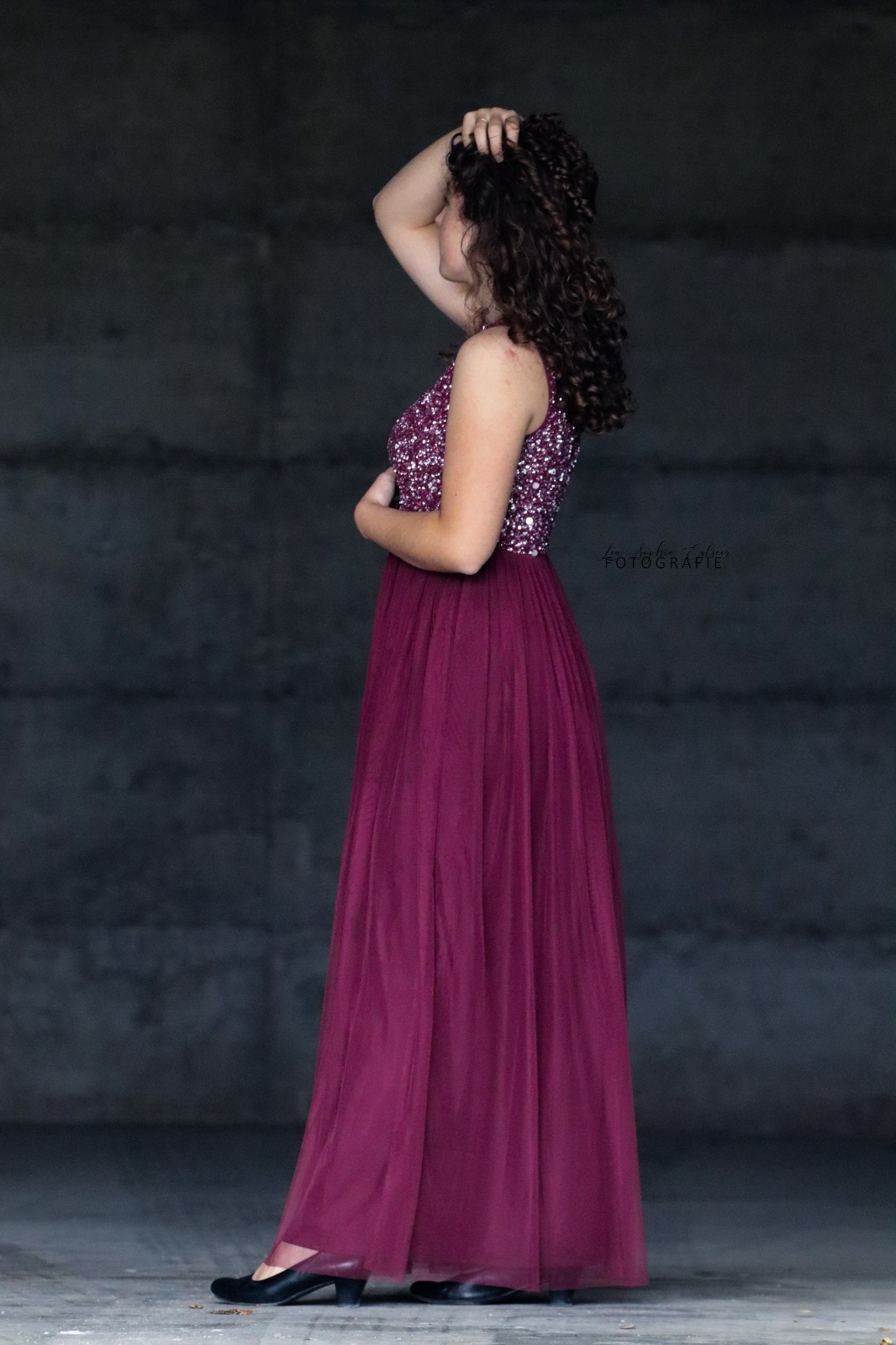 Mädchen in rotem Kleid steht in Halle