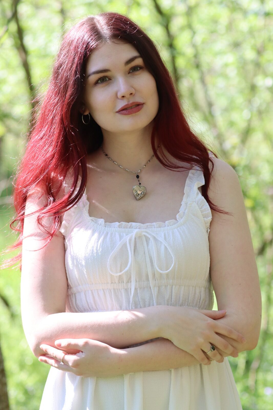 Mädchen mit frühlingsrosa Haaren steht im Wald