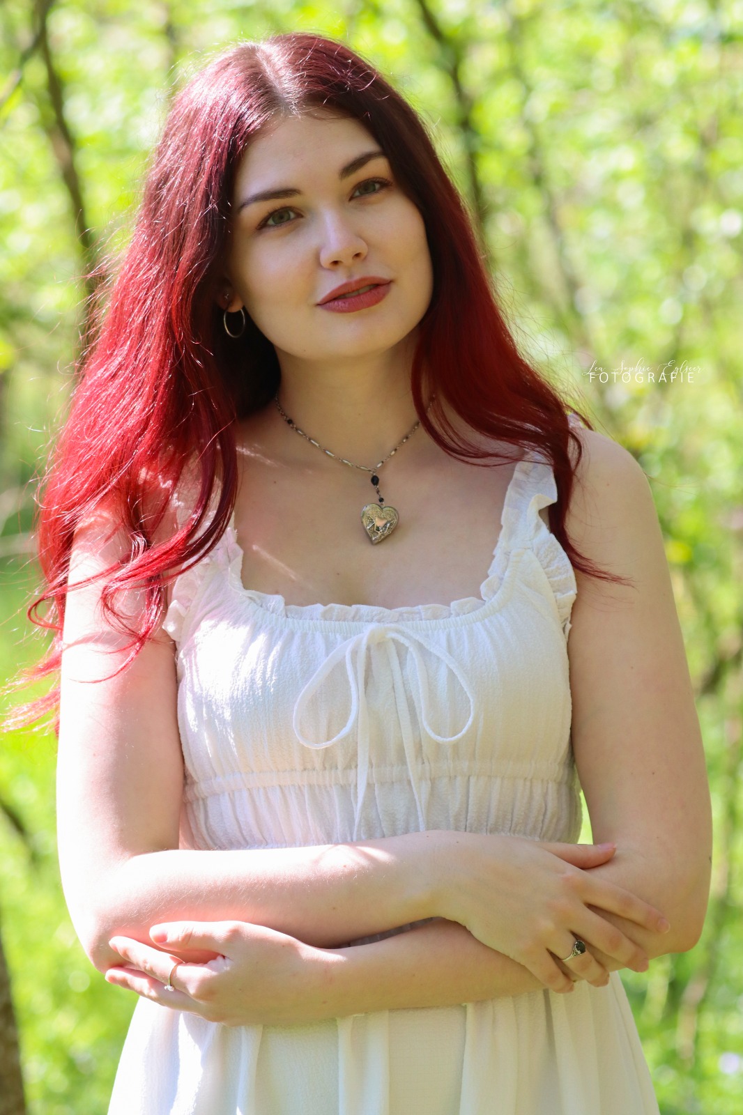 Mädchen mit frühlingsrosa Haaren steht im Wald